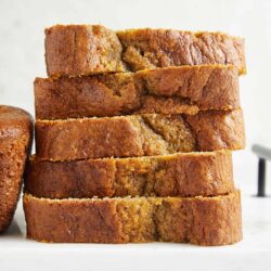 Fudgy banana bread slices on a white cutting board, fresh baked and moist. Perfect for breakfast or snack.