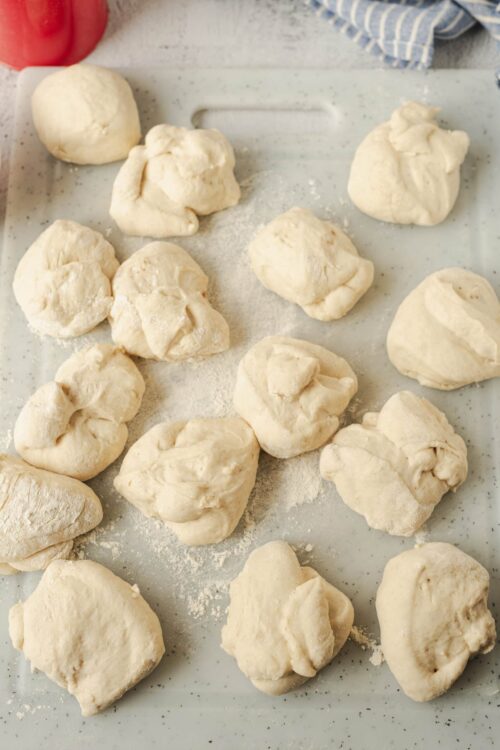 Unbaked homemade biscuit dough balls on a baking sheet, ready to be baked.