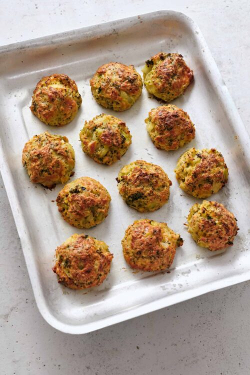 Savory vegetable meatballs baked on a white baking sheet, healthy snack, gluten-free vegetarian recipe.
