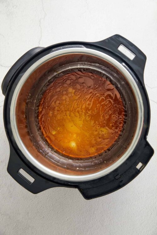 Dark amber honey in a slow cooker, ready for baking or cooking purposes.