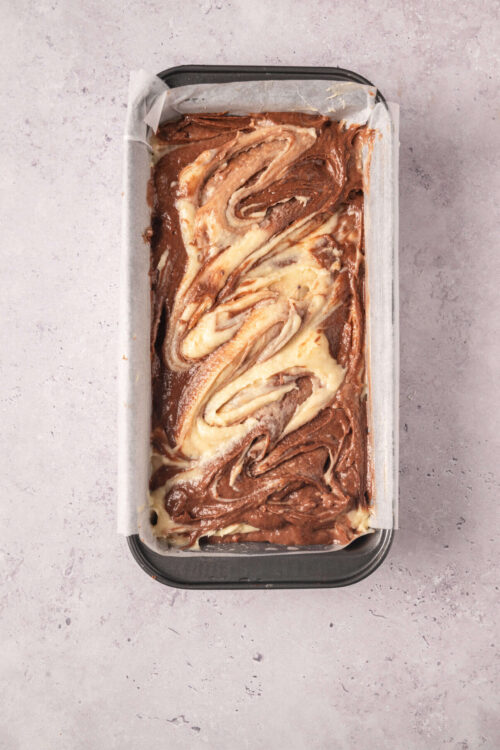 Swirled chocolate and vanilla marbled bread pudding in a baking dish.