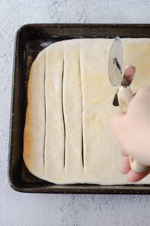Thinly sliced pastry dough in a baking sheet ready for baking.