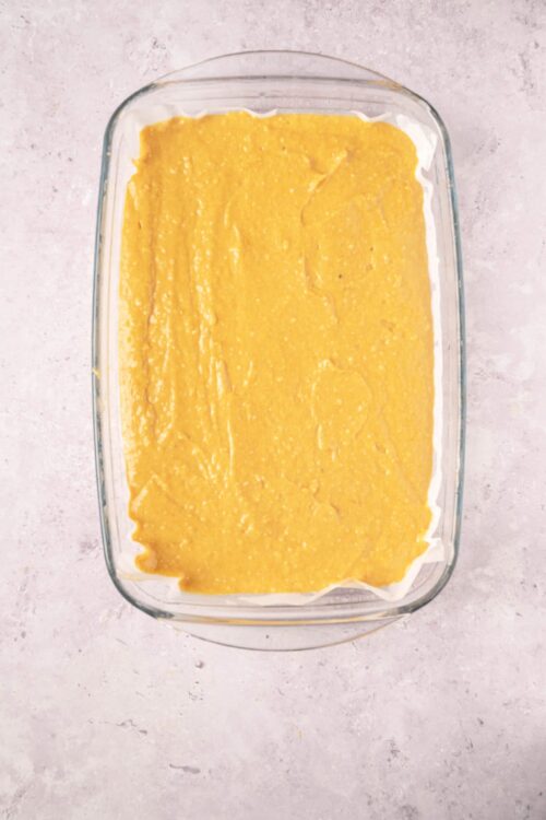 Creamy lemon dessert in a glass baking dish, ready for baking or chilling.