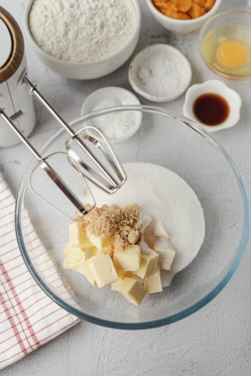 Butter, sugar, and brown sugar in a glass mixing bowl for baking recipes.