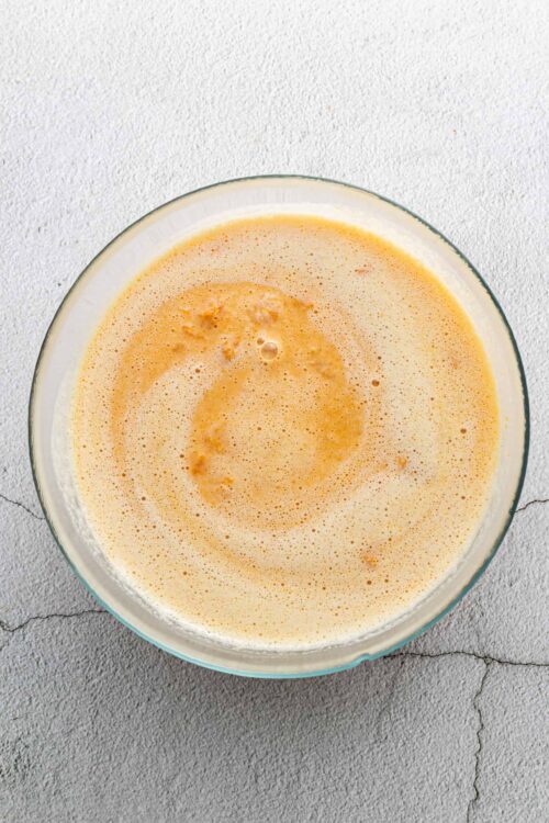 Fluffy homemade pancake batter in a glass mixing bowl.
