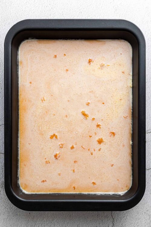 Creamy orange custard in a baking dish ready to bake for a dessert recipe.