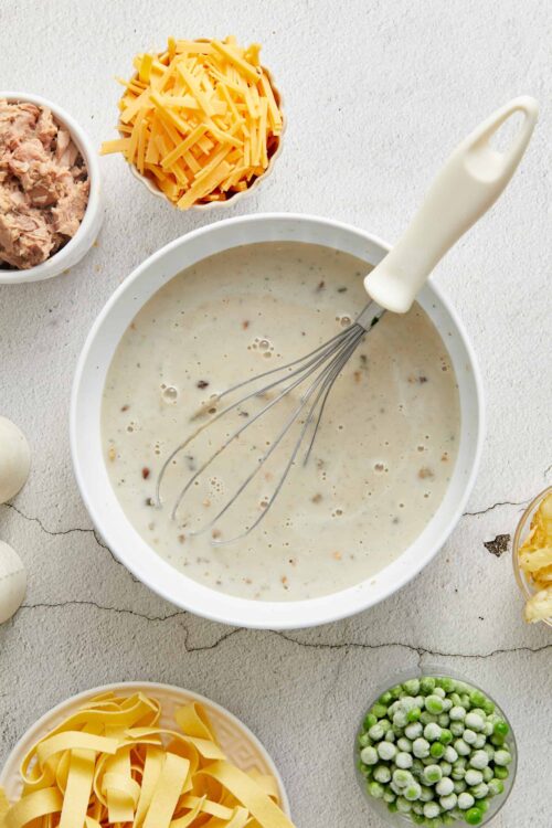 Creamy white sauce with cheese and seasoning, ready for cooking or baking.
