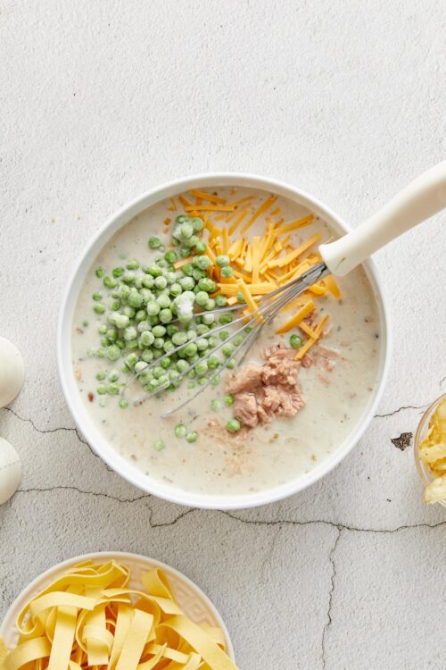 Creamy chicken and vegetable soup with shredded cheese, peas, and a comforting broth.