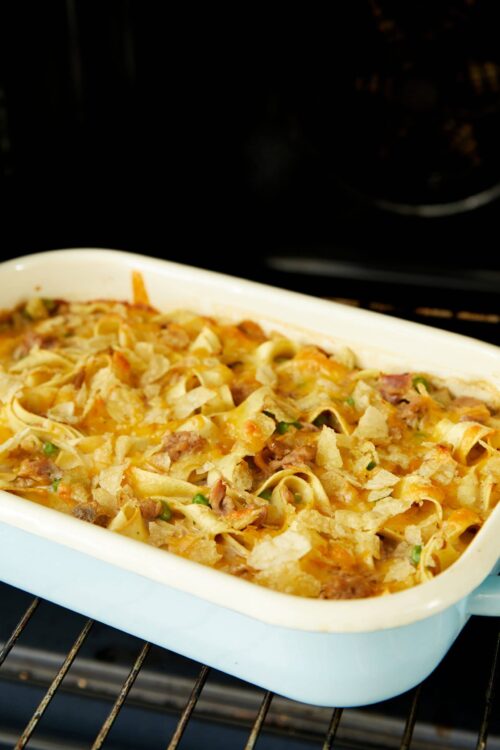 Creamy baked pasta casserole with cheese, meat, and crispy topping in a baking dish.