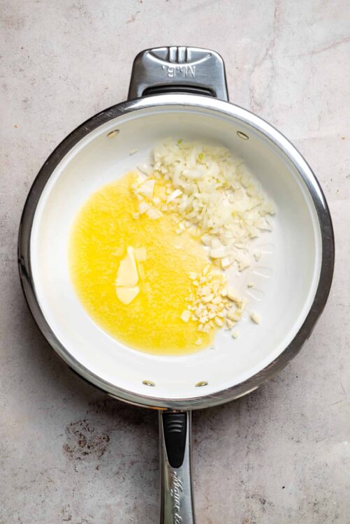 Cream cheese and chopped onions in an Instant Pot, ready for cooking.