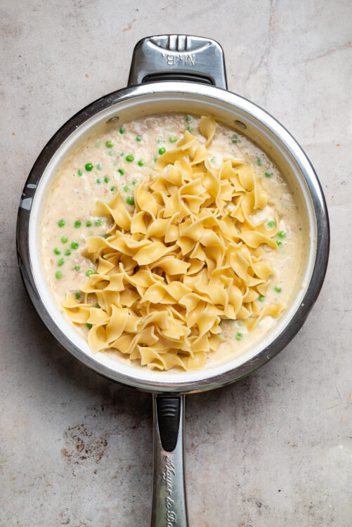 Creamy chicken and green pea pasta in a skillet, ready to serve easy comfort food recipe.