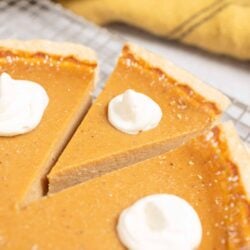 Butter pecan pie slices with whipped cream on top.