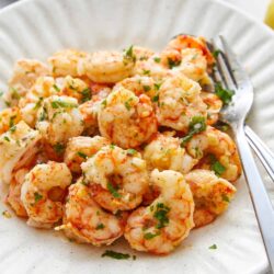 Savory shrimp scampi dish garnished with fresh parsley on a white ceramic plate. Perfect for seafood lovers and easy to prepare at home.