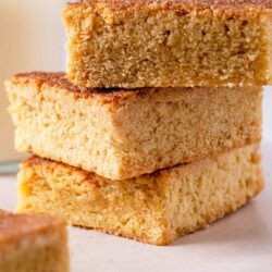 Butterscotch blondies with a golden brown crust, stacked on parchment paper. Perfect for easy baking and dessert recipes.
