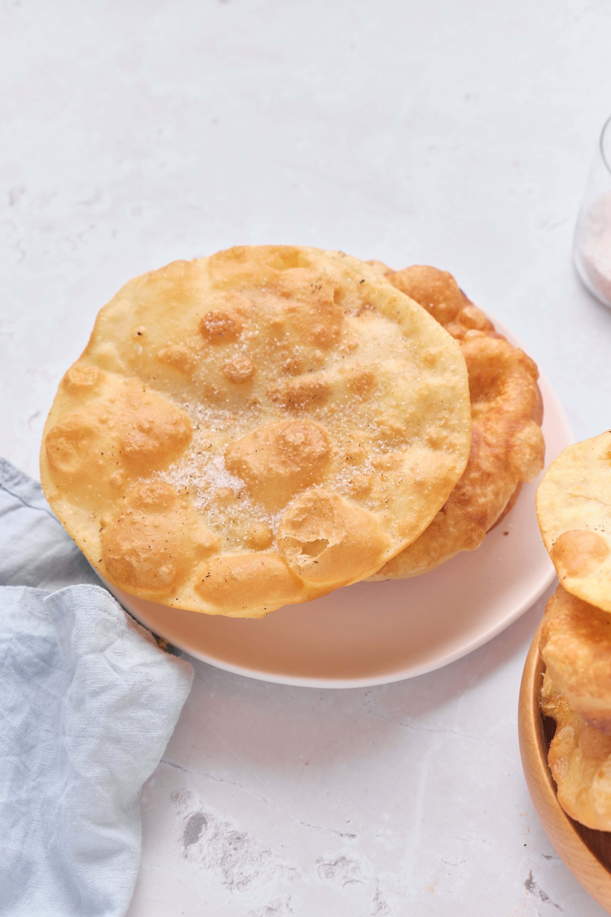 Fluffy homemade fried bread served on a white plate, crispy and golden brown.