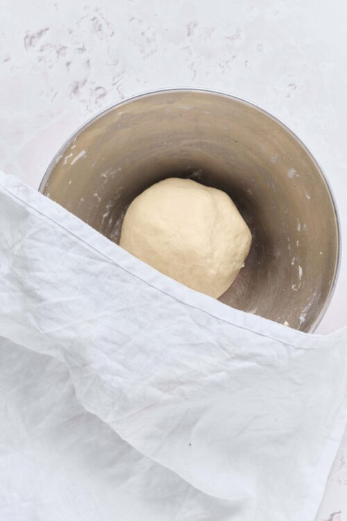 Soft, smooth bread dough resting inside a mixing bowl.