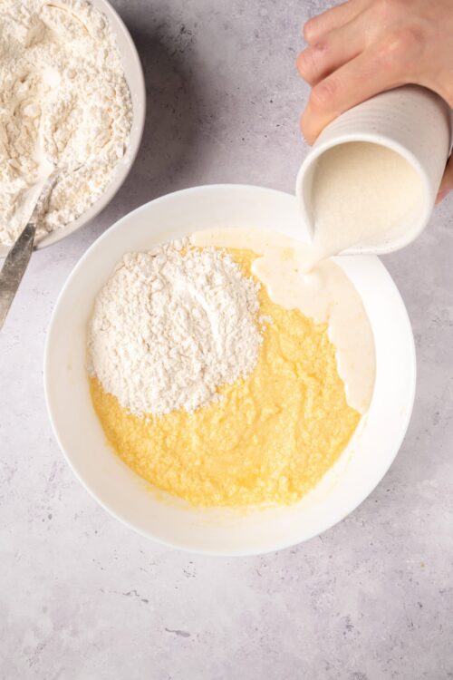 Flour and batter mixture being prepared for baking, with pouring of milk into dry ingredients.