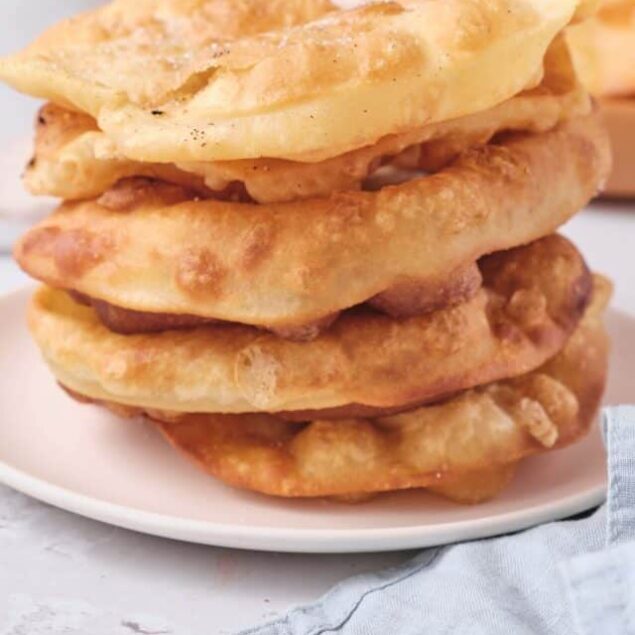 Golden fried bread called Indian frying bread or naan. Traditional Indian homemade fried bread stack with crispy and soft textures.