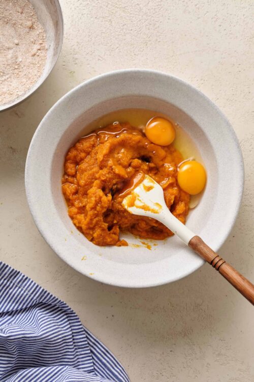 Crustless Pumpkin Pie ingredients being mixed in a white bowl with eggs and spices for a delicious baked dish.