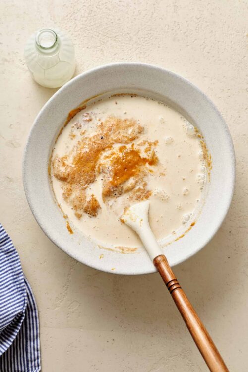 Cool Whip in a mixing bowl with milk and vanilla extract, ready for making creamy homemade whipped topping or dessert.