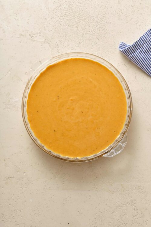 Creamy cheese sauce in a clear glass bowl, ready for baked cheese dishes or dipping.