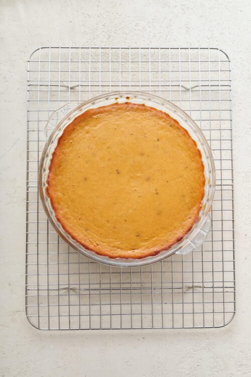 Famous pumpkin pie cooling on a wire rack, ready to serve. Perfect for fall desserts and Thanksgiving celebrations.