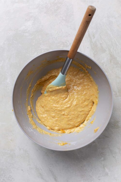 Creamy batter mixture in a mixing bowl with a spatula for baking recipes.