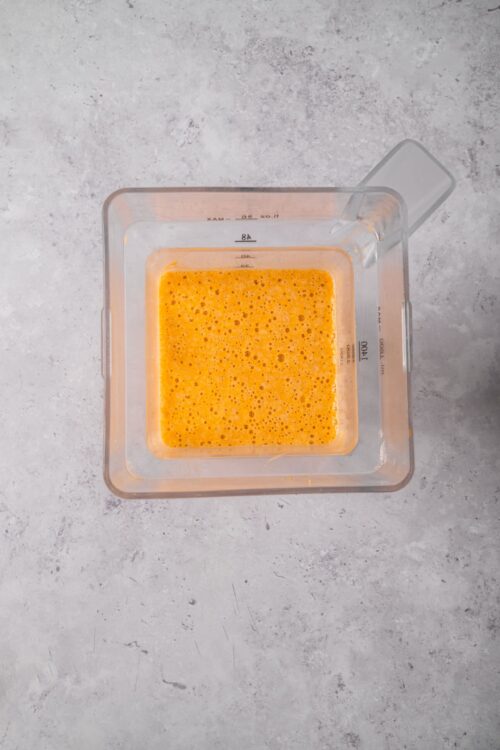 Baked egg mixture in a clear measuring cup on a gray surface.