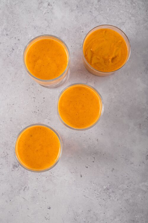 Creamy butternut squash soup in clear glasses, perfect for fall or winter meal ideas.