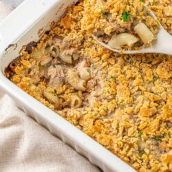 Creamy tuna casserole with crispy breadcrumb topping in a white baking dish.