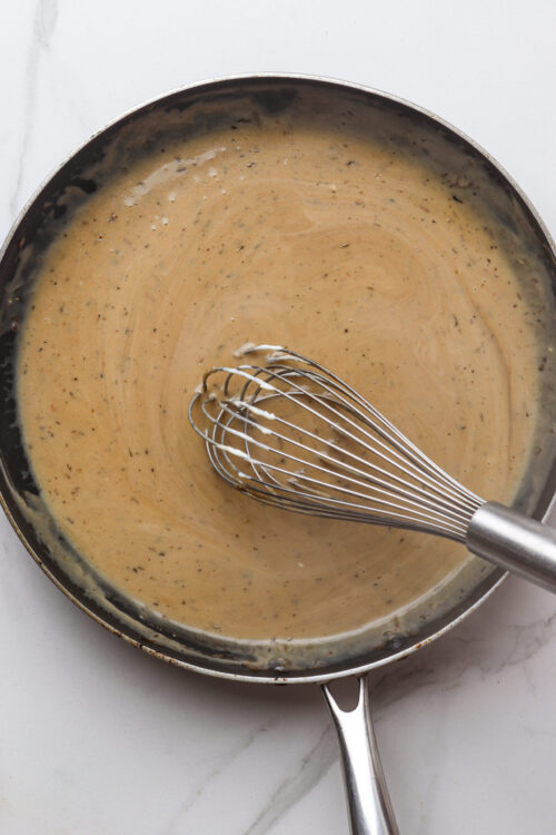 Creamy sauce being whisked in a skillet, homemade cooking, Italian cuisine, culinary step, Baked Bree recipe.