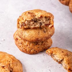 Soft chocolate chip cookies with gooey center and crispy edges on a light grey background.