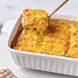 Cheesy chicken enchiladas casserole with melted cheese and fresh herbs.