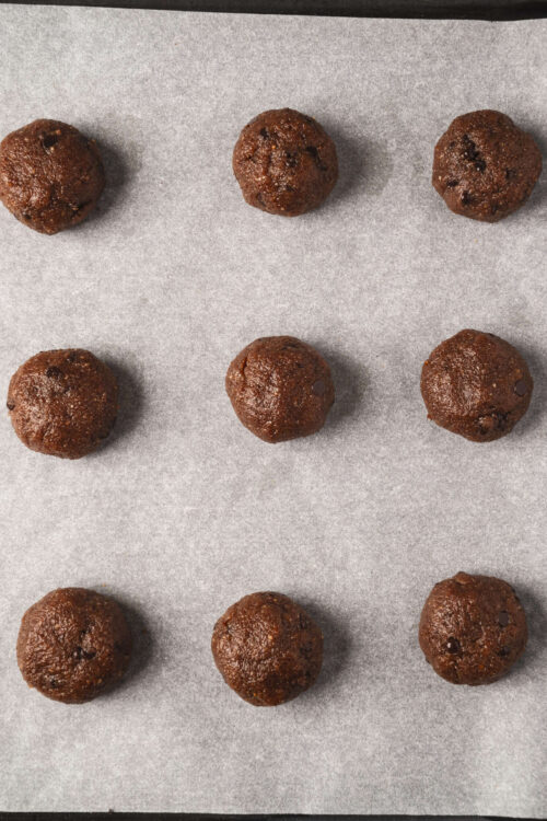 Rich chocolate protein ball bites on baking parchment.