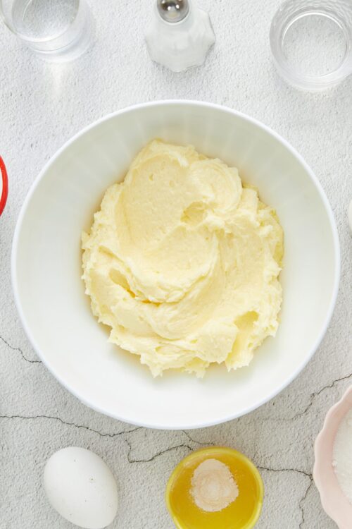 Creamy homemade mashed potatoes with butter in a white bowl for comforting side dish.
