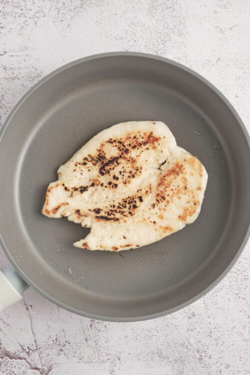 Golden grilled chicken breast in non-stick skillet, healthy grilled chicken recipe.