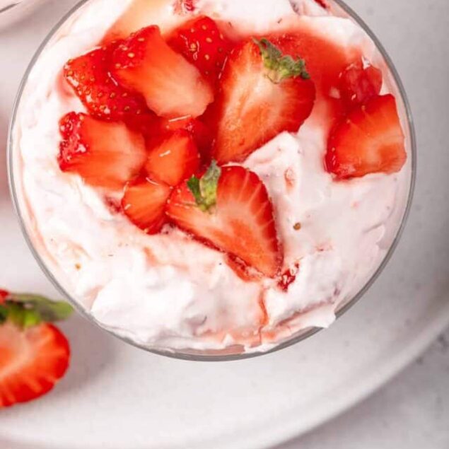 Fresh strawberry shortcake dessert with whipped cream and sliced strawberries.