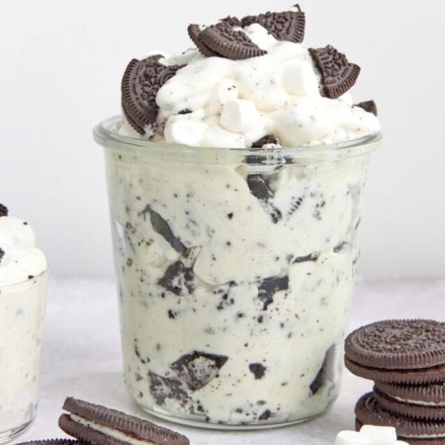 Creamy cookies and cream ice cream with chopped Oreo cookies and mini marshmallows in a glass jar.