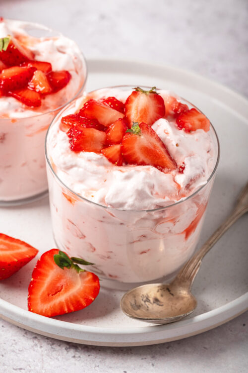 Sweet strawberry shortcake dessert with fresh strawberries and whipped cream in a glass.